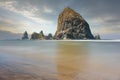 Huge high rock with a cloudy sky on the horizon in Cannon Beach, Oregon