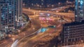 Huge highway crossroad junction with tunnel near JLT district aerial night timelapse.