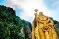 View from below of golden statue of hindu god murugan outside batu caves during cloudy day in kuala lumpur, malaysia Royalty Free Stock Photo