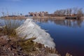 A huge ice floe sails along the calm blue river. On the other side are reflected in the water houses, trees. Spring, St. Petersbur Royalty Free Stock Photo