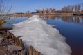 A huge ice floe sails along the calm blue river. On the other side are reflected in the water houses, trees. Spring, St. Petersbur Royalty Free Stock Photo