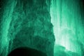 Huge ice icicles. Large blocks of ice frozen waterfall or water. Light green ice background. Frozen stream waterfal