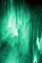 Huge ice icicles. Large blocks of ice frozen waterfall or water. Light green ice background. Frozen stream waterfal