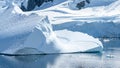 Tiny Penguins on Ice Floe and on Huge Iceberg with Fissure in Antarctica near Petermann Island