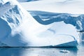 Tiny Penguins on Ice Floe and on Huge Iceberg with Fissure in Antarctica near Petermann Island