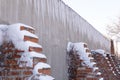 Huge icicles and heavily snow-covered ledges against the wall