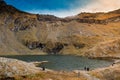 Huge lake in the mountains with a little house on the dock. Nice blue sky with some clouds. Shot in Romania, Transfagarasan