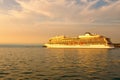 Huge luxury cruise ship glides out of the port of Koper during magic sunset. Colorful vibrant sky. Travel and tourism concept.