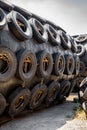 A huge Marine Pneumatic heavy rubber fender surrounded by tires fixed with chains