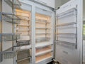 Huge modern refrigerator with empty shelves in a kitchen.