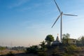 Huge modern windmill on hills with buildings in front and blue sky behind Royalty Free Stock Photo