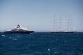 Huge motor megayacht and sailing yacht are near port of Monaco at sunset, water angle view, megayachts are moored in sea