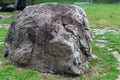 Huge natural stone in the park on the grass