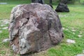 Huge natural stone in the park on the grass