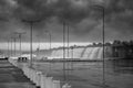 A huge ocean waves breaking on the breakwater at the cloudy stormy day. Breathtaking romantic seascape in the port pier. Bw photo Royalty Free Stock Photo