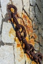 Huge old rusty chain on the stones of the pier Royalty Free Stock Photo