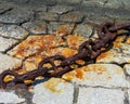 Huge old rusty chain on the stones of the pier Royalty Free Stock Photo