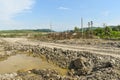 Huge open pit coal mine made with big excavators, loaders, trucks and stacking machines. Heavy industrial machines for brown coal