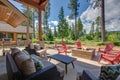 Back yard with fire pit and red chairs near newly bild luxury real estate home with forest biew and green grass Royalty Free Stock Photo