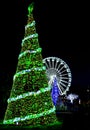 Huge outdoor illuminated Christmas tree with ferris wheel in background in Bournemouth, Dorset, UK