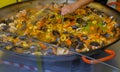 Huge pan with paella and seafood close-up. Cooking street food. Spain traditional meal