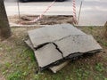 a huge piece of cut asphalt for patch repair of the road surface in the courtyard against the backdrop of a hole in the road