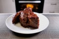 Huge piece of meat on plate. Roast beef close-up. Barbecue meat in modern kitchen. Blurred background oven. Hot cooked dinner.