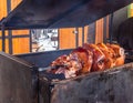 Huge pieces of pork meat roasted on the wood on the street of Prague