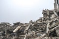 A huge pile of gray concrete debris from piles and stones of the destroyed building. The impact of the destruction