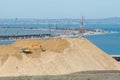 A huge pile of soil in the foreground, and the bend of the bridge under construction across the Ker