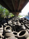 Huge piles from old car tires under a bridge in Varna, Bulgaria. Pollution all around.