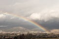 Huge rainbow above village and mountain range Royalty Free Stock Photo