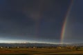 Huge rainbow over the Tuscan countryside against a dark cloudy sky, Bientina, Pisa, Italy