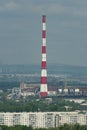 A huge red-white brick chimney in the center of an industrial city. Royalty Free Stock Photo