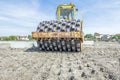 Huge road roller with spikes is compacting soil at construction Royalty Free Stock Photo