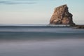 Huge rock cliff isolated in ocean in long exposure in sunset sky, hendaye, basque country, france Royalty Free Stock Photo