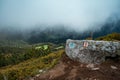 Huge rock on the ground with a background of a landscape in misty weather