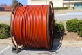 Huge roll of orange cable for underground cable installation sitting along a street Royalty Free Stock Photo