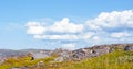 Huge rounded stones on backdrop of hills, small mountains and low Northern the sky.