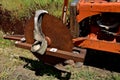 Old rusty saw blade mounted on an orange tractor front