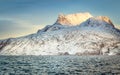 Huge Sermitsiaq mountain covered in snow with blue sea and small fishing boat, nearby Nuuk city, Greenland Royalty Free Stock Photo