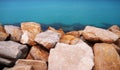Huge sharp stones against a turquoise sea. Seashore of Mahdia, Tunisia