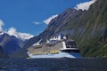 Huge ship cruising in Milford Sound in New Zealand. Ferry in Fjordland. Famous landmark.