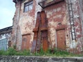 Huge skis on the facade of the old factory. Skis and ski poles are made of rusty metal and lean against the wall. Abandoned