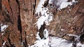 A huge snow cliff. Flows down the waterfall. Huge icicles and ice.