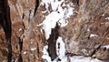 A huge snow cliff. Flows down the waterfall. Huge icicles and ice.