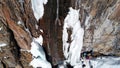 A huge snow cliff. Flows down the waterfall. Huge icicles and ice.