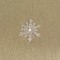 Huge sparkling snowflake on the sand in the sea foam. Concept of Winter and Christmas vacation on the beach Royalty Free Stock Photo