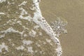 Huge sparkling snowflake on the sand in the sea foam. Concept of Winter and Christmas vacation on the beach and resort.