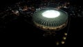 Huge sports arena shining with lights in heart of night megalopolis, aerial shot